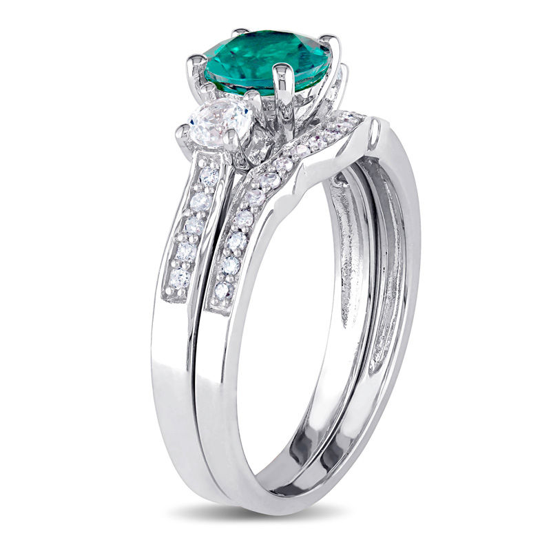 6.0mm Emerald and White Sapphire with 1/8 CT. T.W. Diamond Three Stone Bridal Set in 10K White Gold